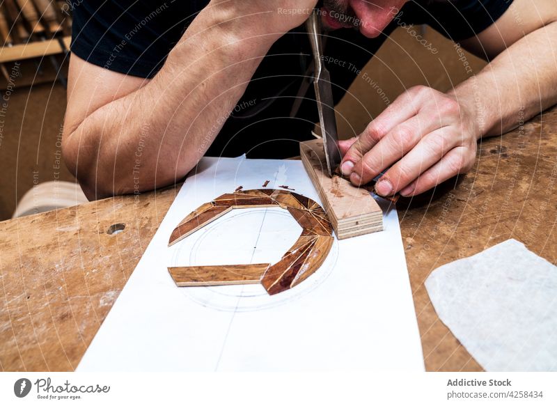 Handwerker schneidet Holzklotz mit Feile in der Werkstatt Kunsthandwerker geschnitten Klotz Holzarbeiten Aktenordner professionell Genauigkeit Mann Arbeitsraum