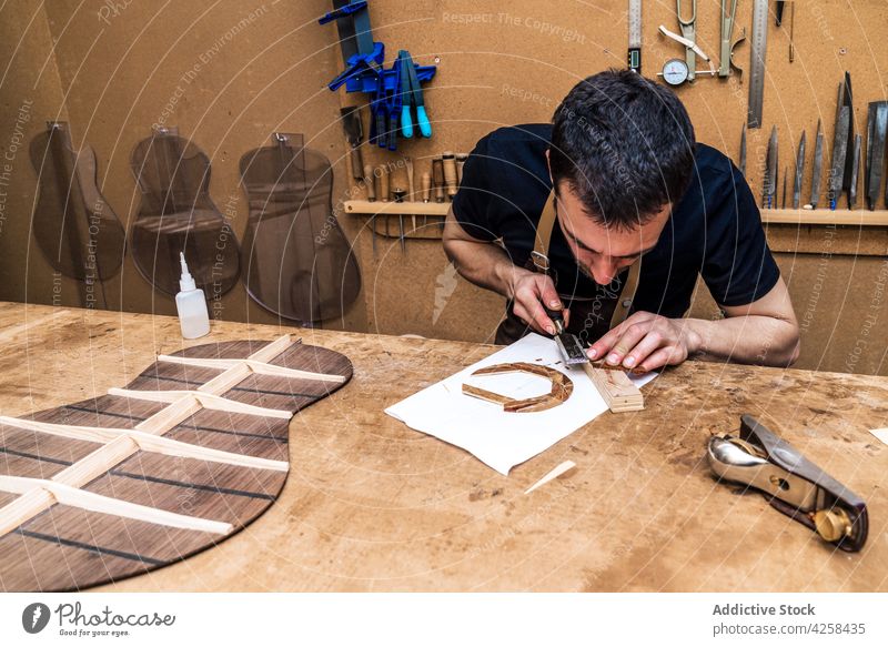 Handwerker schneidet Holzblock mit Feile in der Werkstatt Kunsthandwerker geschnitten Klotz Holzarbeiten Aktenordner professionell Genauigkeit Mann Arbeitsraum