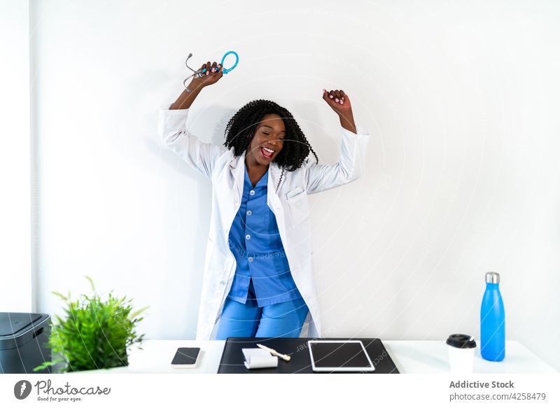 Schwarze Ärztin in medizinischer Uniform tanzt in der Klinik Frau Arzt Tanzen sich[Akk] bewegen Krankenhaus aktiv Freestyle Arbeitsplatz Büro professionell