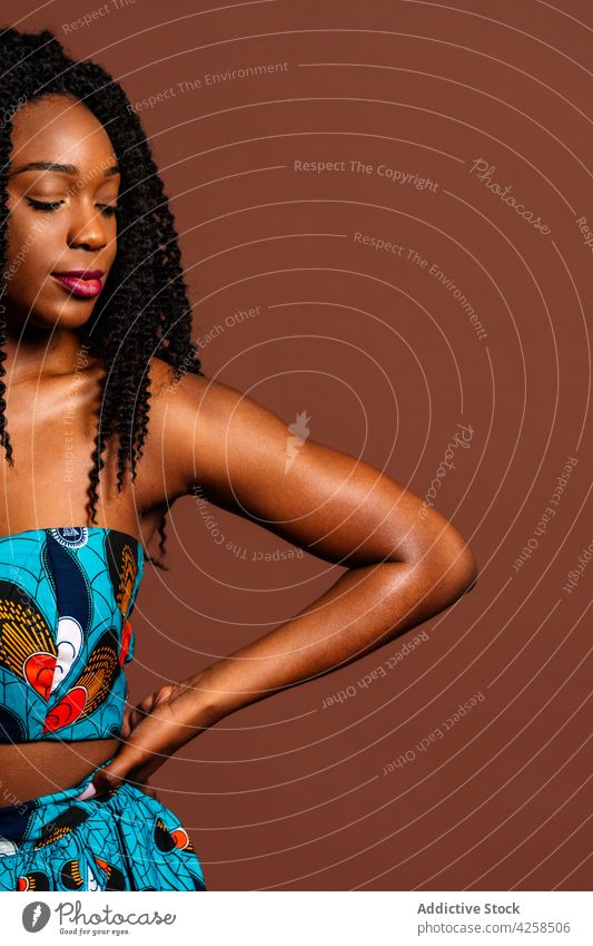 Schwarze Frau in buntem Kleid steht auf dem Boden friedlich Anmut feminin Körperhaltung Stil Afro-Look Individualität Persönlichkeit Gelassenheit lange Haare
