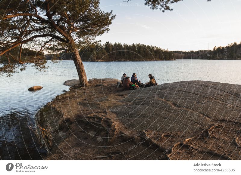 Anonyme Wanderer ruhen sich am Seeufer aus und machen ein Picknick Menschen Ufer Lager Reisender Wald Zusammensein sich[Akk] entspannen Natur Freund Landschaft