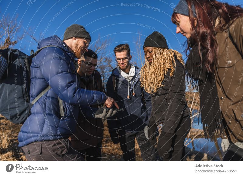 Gruppe verschiedener Wanderer, die mit ihrem Smartphone eine Route suchen Männer Frauen Freund benutzend Fluss Suche navigieren Anschluss zuschauen männlich