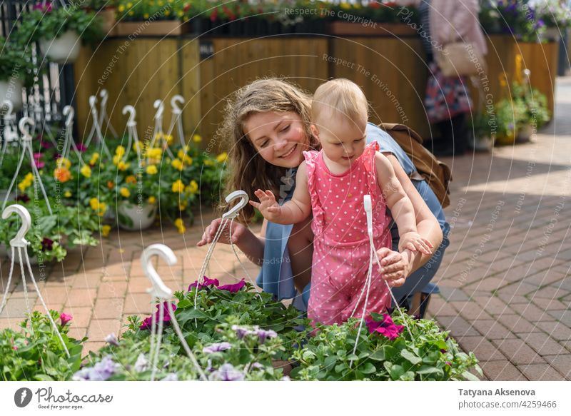 Frau mit Tochter wählen Blumen auf dem Markt kaufen Garten Pflanze Einzelhandel Gartenarbeit Gärtner jung grün Kaukasier Laden Lächeln Erwachsener Gartenbau