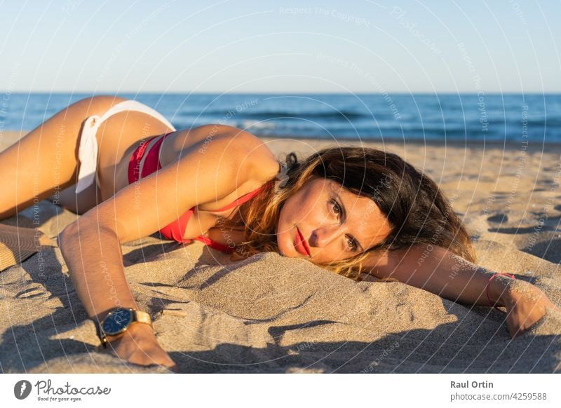 Hübsche junge Frau am Strand liegend Sand .Schöne weibliche genießen Sommer sonnigen Tag .Urlaub und Urlaub Entspannung concept.Copy Raum. Porträt Feiertage