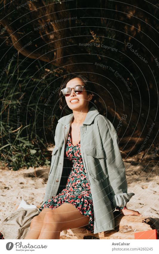 Frau lächelnd am Strand mit Blick auf die Kamera, während mit Sonnenbrille Sommer Konzept Lebensstil lockig Hipster Teenager Lächeln modern Marokkaner jung