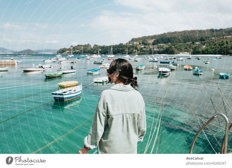 Frau rückwärts vor dem Meer mit einer Menge von Booten während eines sonnigen Tages Person Porträt allein Glamour Freude Sonnenlicht Jacht jung brünett Teint