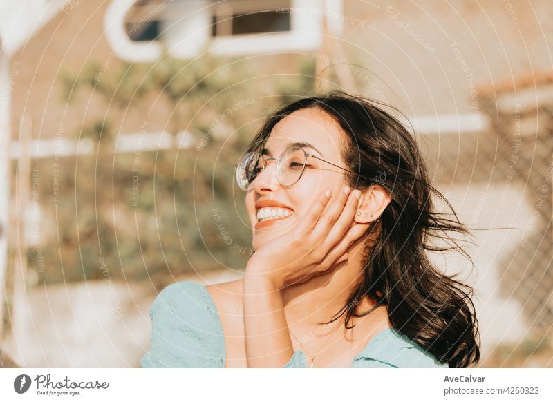 Junge Frau mit Brille lächelnd in die Kamera während einer super sonnigen Tag mit Kopie Raum Lifestyle-Konzept glücklichen Tag Person sorgenfrei genießend