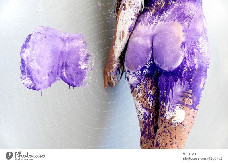 Hip Gesäß und Oberschenkel der jungen sexy Frau mit Farbdruck auf Wand abstrakte Bodypainting mit weiß, lila, lila, violett Farbe, kreative, abstrakte Körperkunst,