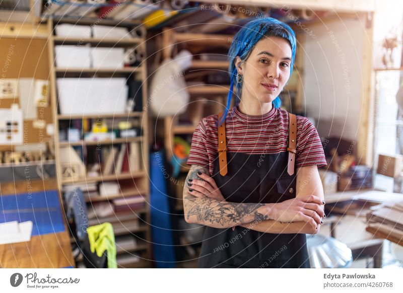 Selbstbewusste junge Handwerkerin in ihrer Werkstatt diy Hipster farbenfroh Behaarung Tattoos Frau Besitzer Beruf Dienst Kleinunternehmen Mitarbeiter arbeiten