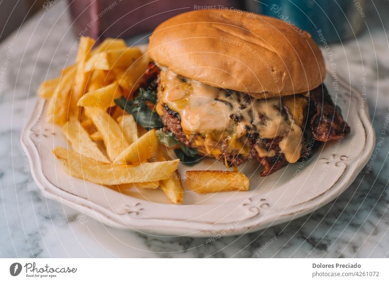 Rindfleisch-Käse-Burger mit Pommes Ketchup isoliert Holzplatte Tisch Cholesterin Mayonnaise-Sauce Rucola Komfortnahrung Textfreiraum verdoppeln Abendessen