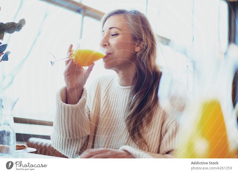Lächelnde Frau beim Frühstück im Restaurant sprechen Getränk Orangensaft Erfrischung Glück offen Freude Zeit verbringen Tee Großvater Tomate trinken Zuprosten