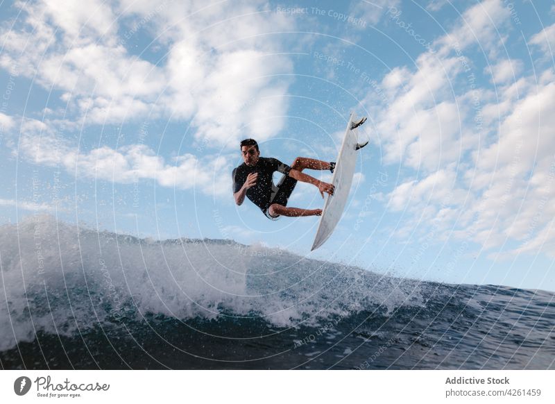 Sportler übt Surfen auf einer Meereswelle Surfer üben extrem winken Energie MEER Mann dynamisch fließen schnell Aktivität Mut Talent Fähigkeit wolkig Himmel
