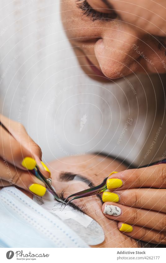 Kosmetikerin trägt Wimpern auf das Gesicht einer Frau auf bewerben Klient Verlängerung Schönheit Kosmetologie Verfahren Frauen Salon Augen geschlossen