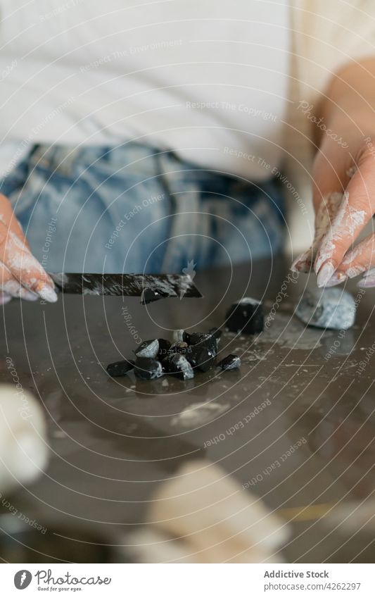 Unkenntlich gemachte Schmuckmacherin mit schmutzigen Händen beim Schneiden von Material Frau geschnitten dreckig Herstellerin Designer Werkstatt Handwerkskunst