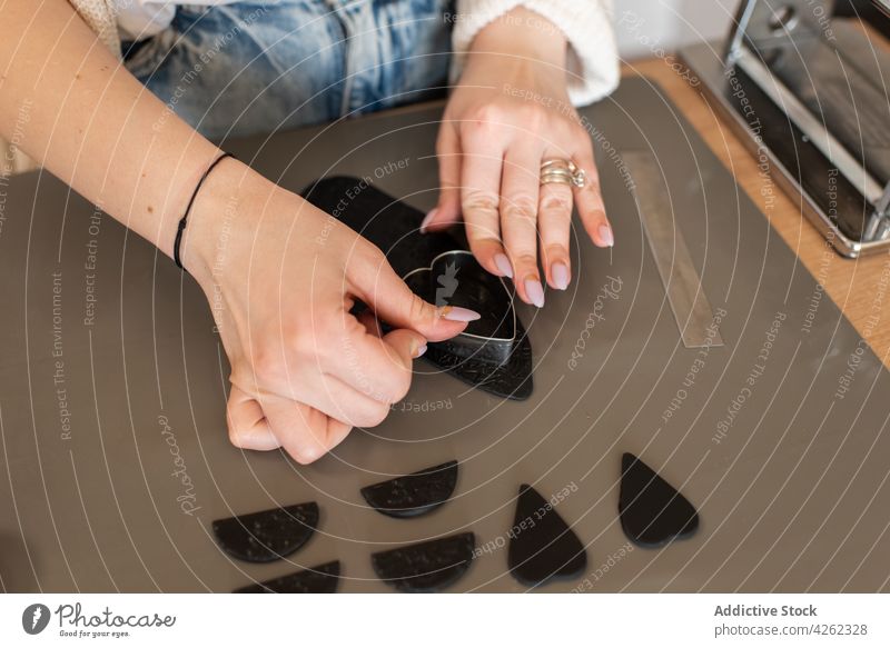 Crop gesichtslose Handwerkerin formt Details aus schwarzem Ton Frau handgefertigt Formular Basteln kreieren Accessoire diy Hobby Schmuck Fähigkeit