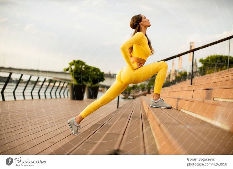 Junge Frau streckt sich am Flussufer jung Joggen Training Fitness nach oben Läufer Athlet Menschen Lifestyle Gesundheit Person Körper Sommer Beine