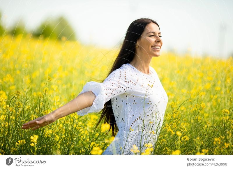 Junge Frau auf dem Rapsfeld schön Feld außerhalb gelb Sommer im Freien Schönheit Glück Frühling Person Wiese Natur Blume Freiheit Lifestyle sonnig geblümt