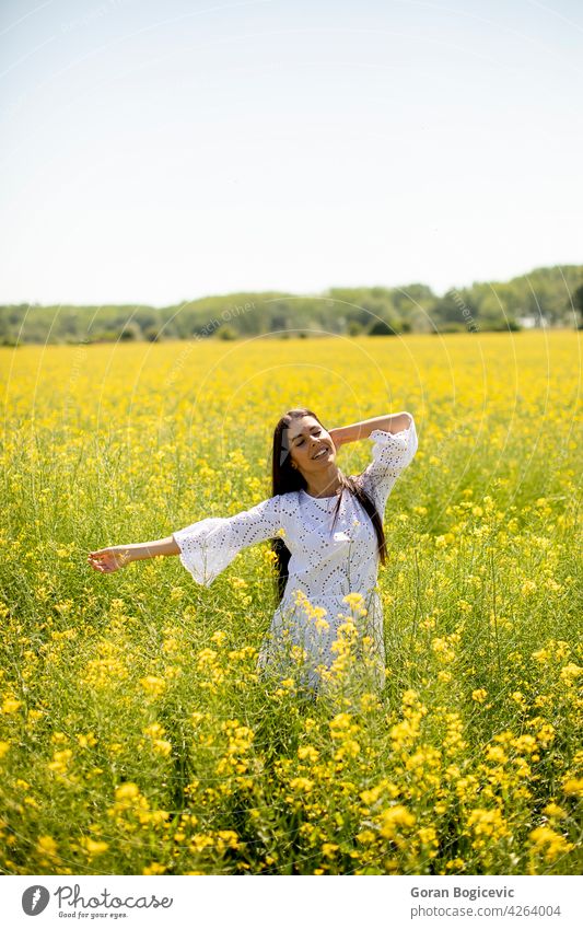 Junge Frau auf dem Rapsfeld schön Feld außerhalb gelb Sommer im Freien Schönheit Glück Frühling Person Wiese Natur Blume Freiheit Lifestyle sonnig geblümt