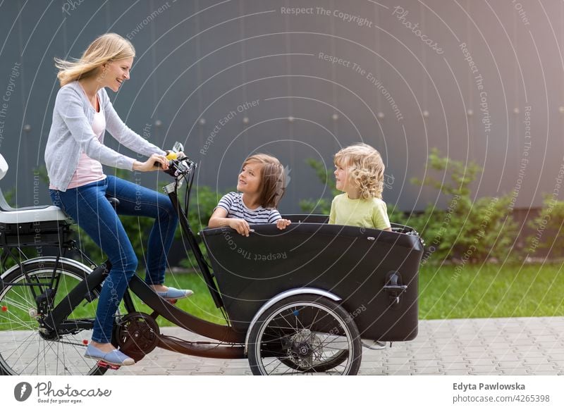 Mutter und Kinder haben eine Fahrt mit Fracht Fahrrad Dreirad Lastenrad Tag Gesundheit Lifestyle aktiv im Freien Spaß Freude Zyklus Radfahren Aktivität