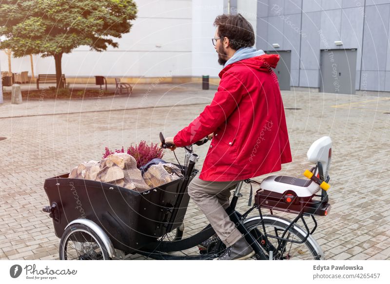 Mann auf dem Rückweg vom Einkaufen mit einem Lastenfahrrad tragen Dreirad Lastenrad Tag Gesundheit Lifestyle aktiv im Freien Freude Fahrrad Zyklus Radfahren