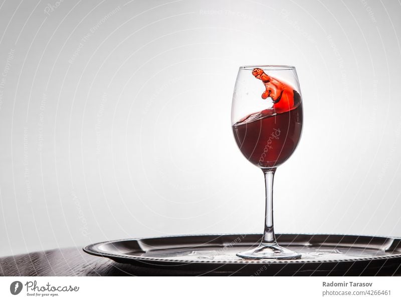 Rotwein schwappt aus einem Glas rot Weinglas Alkohol trinken Tropfen Bewegung platschen Aktion verschütten Getränk eingießen Geplätscher weiß Weingut fließen