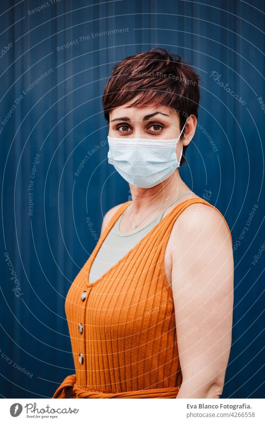 kaukasische Frau im Freien trägt Gesichtsmaske. Pandemie während Corona-Virus soziale Distanz Konzept. Kaukasier Porträt Großstadt urban Freizeitkleidung jung