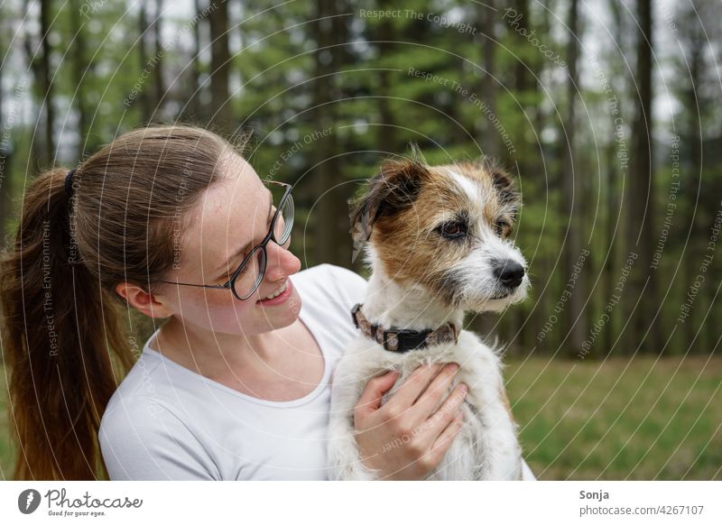 Junge lächelnde Frau mit einem kleinen Hund auf dem Arm Lächeln jung Terrier Haustier Tier niedlich Glück Porträt schön Lifestyle Freundschaft Außenaufnahme