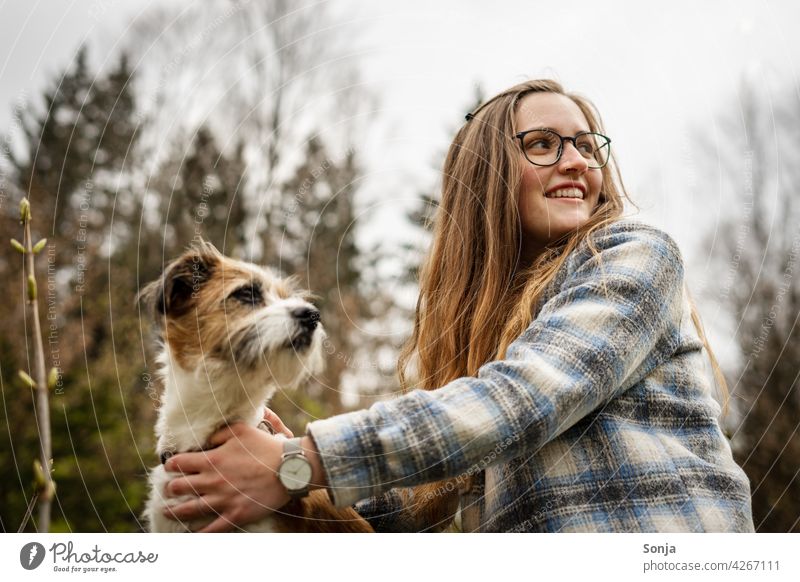 Junge lächelnde Frau mit Brille und einem kleinen Hund draußen im Park Lächeln jung Terrier Baum Haustier niedlich Glück Lifestyle schön Porträt Freundschaft