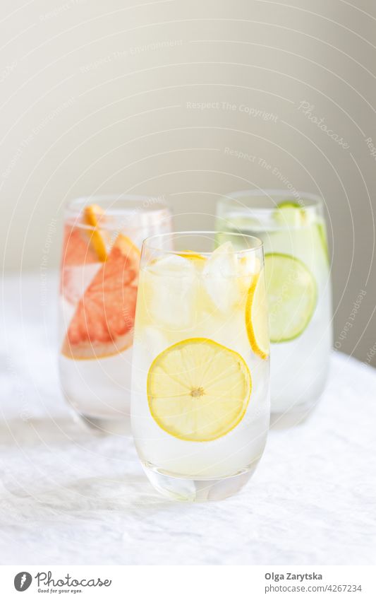 Drei Gläser mit kaltem Zitruswasser. trinken Limonade Wasser Eis Zitrone Grapefruit Kalk Sommer Glas Erfrischung Zitrusfrüchte Schweiß Kulisse Getränk drei