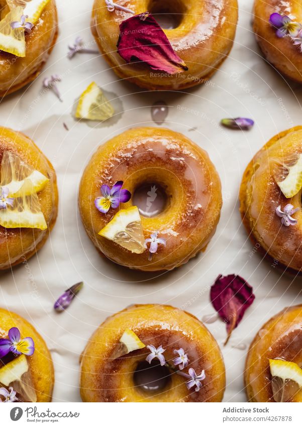 Leckere Donuts mit frischen Zitronenscheiben auf dem Gestell Doughnut Lavendel Gebäck Leckerbissen süß Krapfen Aroma lecker frittiert Kühlregal Reihe ähnlich