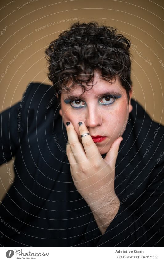 Exzentrischer Mann mit leuchtendem Make-up und Maniküre androgyn exzentrisch feminin ungewöhnlich einzigartig hell Stil Vorschein männlich Kosmetik alternativ