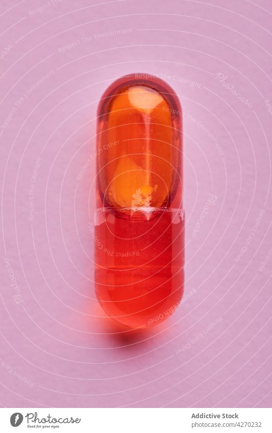 Orangefarbene Pillen auf rosa Oberfläche Tablette Medikament Kapsel Kur Zusammensetzung orange Abhilfe Vitamin Leckerbissen Apotheke Gesundheitswesen Konzept