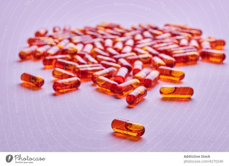 Orangefarbene Pillen auf rosa Oberfläche verstreut Tablette Medikament Kapsel Kur Streuung Zusammensetzung orange Abhilfe Vitamin Leckerbissen Apotheke