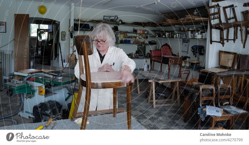 Restaurator in seiner Werkstatt arbeiten Arbeit Stühle Stuhl Antiquitäten alt Maschinen Atelier Handwerk Beruf Arbeitsplatz Herstellung Fähigkeit Meister Job