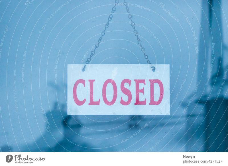 Geschlossenes Schild mit einer Reflexion von schneebedeckten Häusern Werbung blau Business abschließen zugeklappt geschlossenes Zeichen Nahaufnahme kalt Komfort