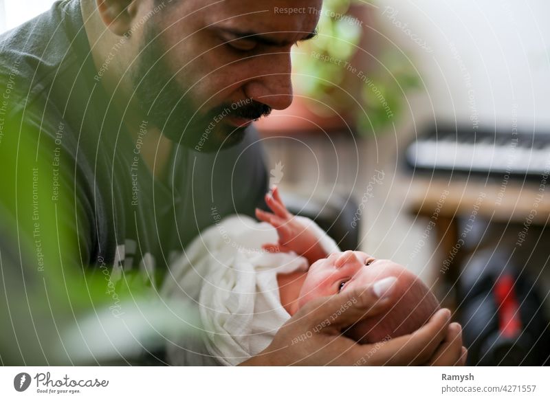 Vater schaut auf neugeborenes Kind. Eltern Papa Pop Vollbart Person der Hautfarbe lateinamerikanisch Latein hispanisch litinx Mann poc Hand Hände Baby Säugling