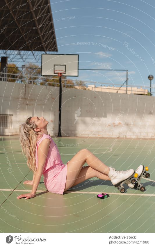 Frau in Rollschuhen auf einem Sportplatz sitzend Skater Rolle Sportpark Aktivität Glück Hobby genießen Augen geschlossen sportlich Energie Lifestyle trendy jung
