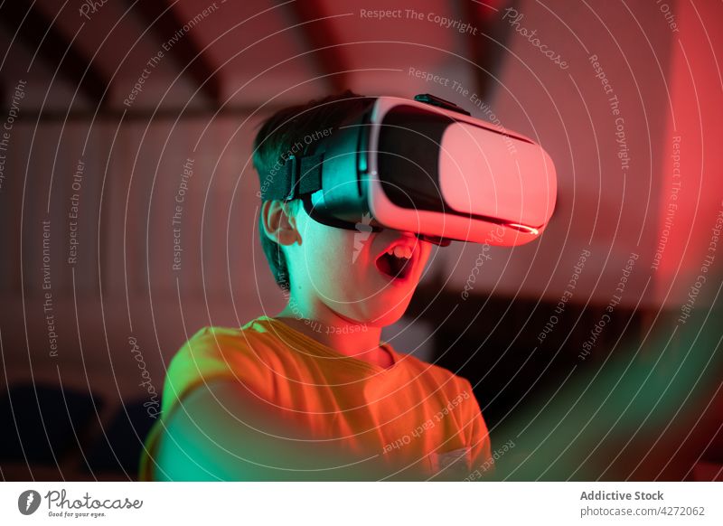 Niedliches Kind mit VR-Brille spielt Videospiele Virtuelle Realität spielen unterhalten Innovation Junge digital Gerät Spaß überrascht virtuell lässig