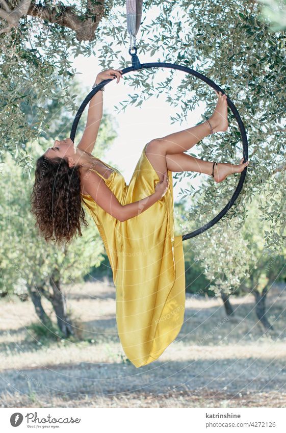Junge Turnerin posiert auf einem Aeriel-Kreis Frau Pose Antennenkreis kreisen sportlich Garten Olivenbaum grün Kleid Sport Luftreifen jung Training Tanzen