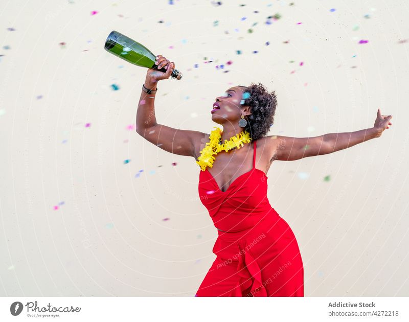 Glückliche schwarze Frau mit Glasflasche Champagner heiter Flasche Feiertag feiern Freude Veranstaltung aufgeregt Alkohol elegant Spaß festlich froh Anlass