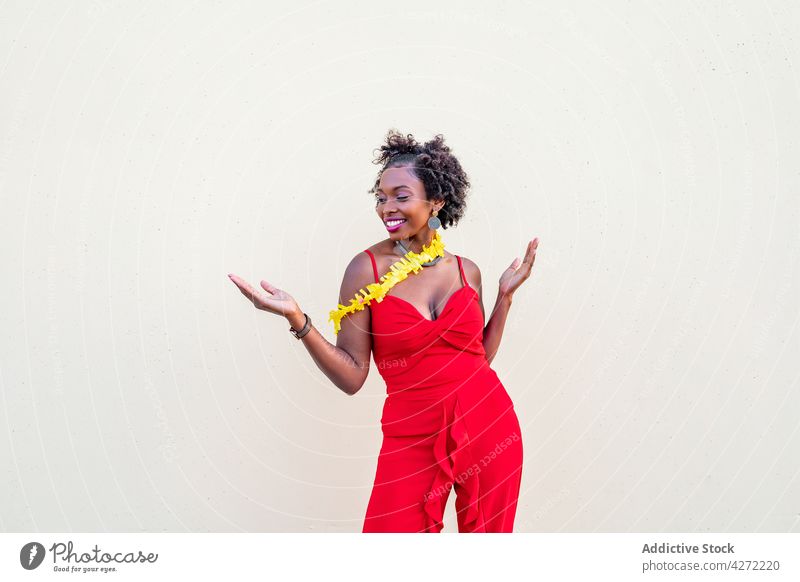 Glückliche afroamerikanische Frau, die in der Nähe einer weißen Wand steht Feiertag feiern Lachen erstaunt Spaß expressiv positiv Freude sorgenfrei festlich