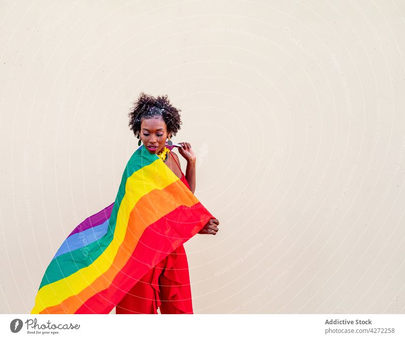 Stilvolle schwarze Frau mit LGBTQ-Flagge auf hellem Hintergrund lgbtq Fahne Mode Stolz Gleichstellung Toleranz Individualität Regenbogen Ornament feiern