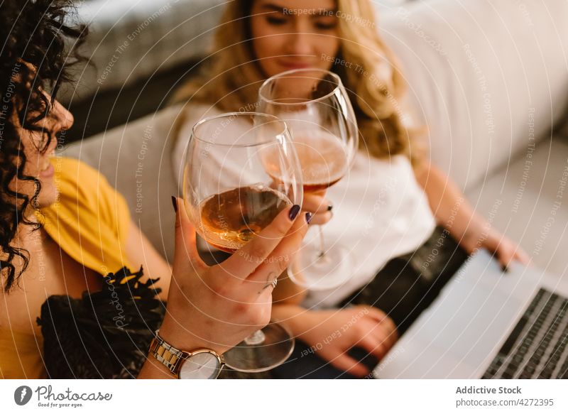 Crop-Frauen stoßen mit Weingläsern an und benutzen einen Laptop Paar Klirren Zuprosten feiern trinken Zusammensein lesbisch lgbt jubelt Partnerschaft Freundin