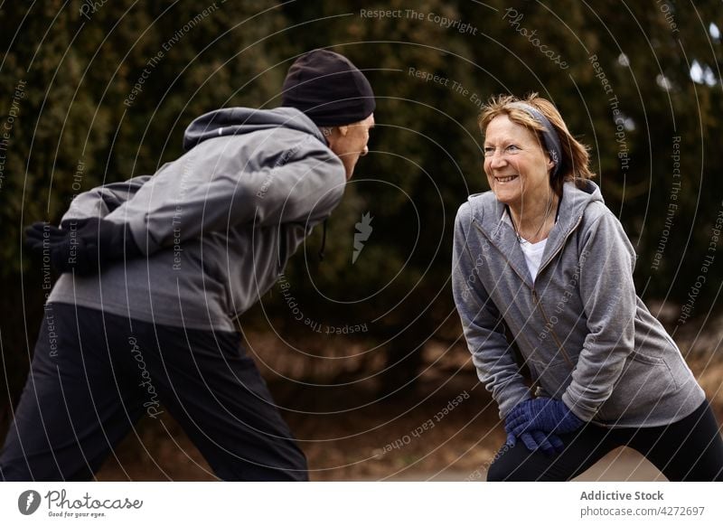 Lächelndes älteres Paar spreizt die Beine beim Training Senior Sport Übung ausdehnen Dehnung genießen aktiv Aktivität Mann Frau Zusammensein gealtert positiv