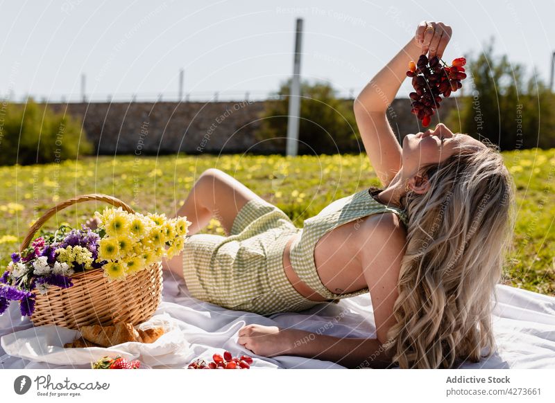 Junge Frau isst Weintrauben beim Picknick Traube Haufen Frucht Korb Blume Natur Landschaft Waldwiese Lebensmittel frisch Blütezeit geschmackvoll reif Pflanze