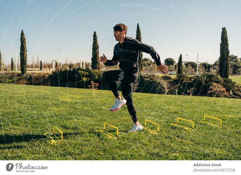 Aktiver Sportler springt beim Ausdauertraining im Park springen Herz Training Aktivität Übung Energie Mann dynamisch üben Turnschuh Sprung Wohlbefinden