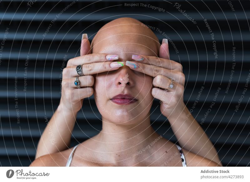 Anonyme Frau, die die Augen einer haarlosen Frau auf der Straße abdeckt Frauen Augen abdecken Alopezie Windstille Zusammensein Freund Krankheit kahl Problematik