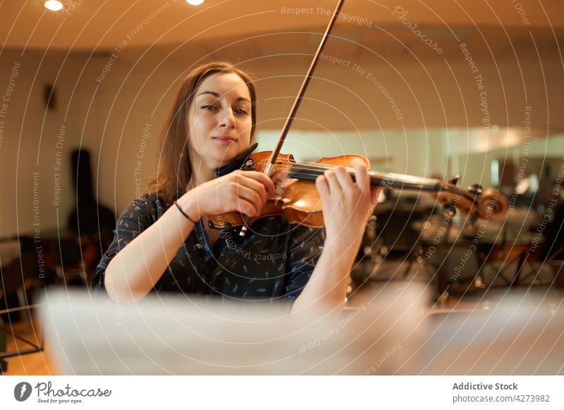 Eine Geigerin spielt klassische Musik in einem Saal Frau Musiker spielen ausführen Probe Instrument Fähigkeit Melodie Klang Talent Atelier akustisch Audio