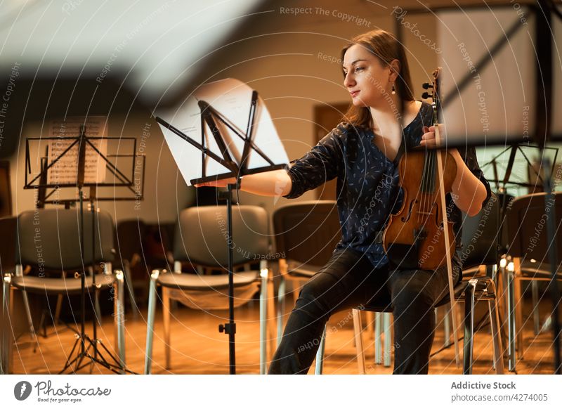 Eine Geigerin spielt klassische Musik in einem Saal Frau Musiker spielen ausführen Probe Instrument Fähigkeit Melodie Klang Talent Atelier akustisch Audio
