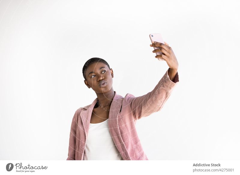 Stylische schwarze Frau macht Selfie mit Smartphone Mode Kuss Stil Glück Moment Gedächtnis genießen benutzend Apparatur Gerät Selbstportrait Funktelefon